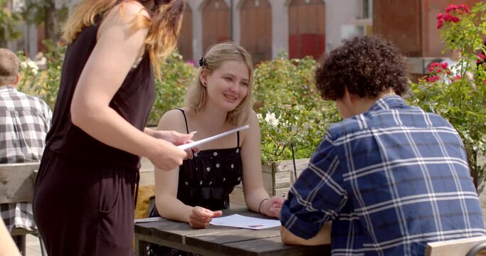 Questionnaire Distribution. At the speed dating event, the event organizer provides participants with questionnaires that contain a series of prompts and questions. Young woman organizes leisure time.