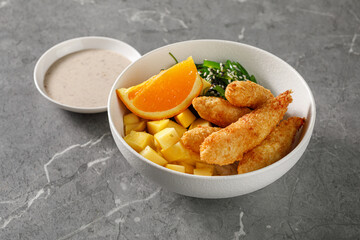 bowl of fried shrimps with orange and mango