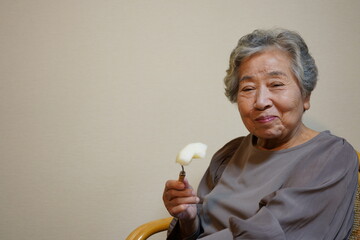 果物を食べる高齢女性