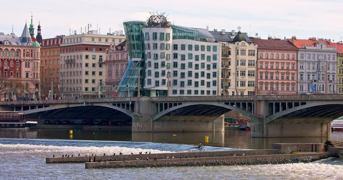 Dancing House and Jir&aacute;sek bridge over Vltava river in Prague city.