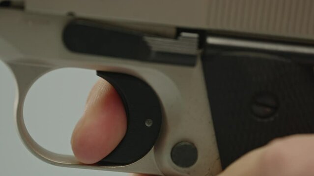 Beautiful macro of finger pulling trigger of pistol