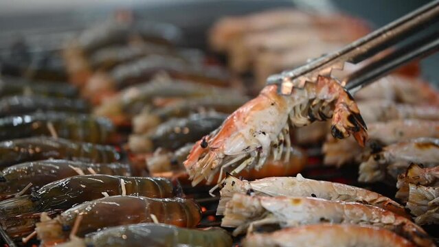 The footage of grilled giant shrimps Sale in the fresh street food market. Giant Freshwater River Prawn in Seafood Restaurant.