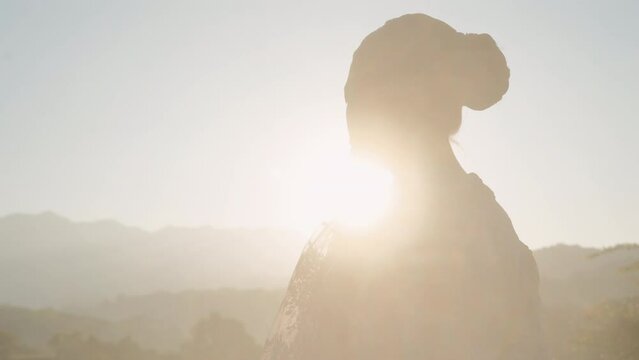 Woman Standing Against The Foggy Golden Horizon