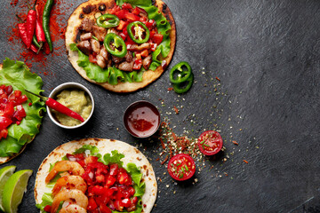 Tacos with salsa, vegetables and avocado on black background