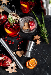 Winter christmas cocktail with pomegranate and rosemary in a glasses on black background. Top view
