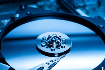 Disassembled open hard disk drive HDD of computer or laptop. Place it on a dark blue light background. the concept of data, hardware, and information technology - obrazy, fototapety, plakaty