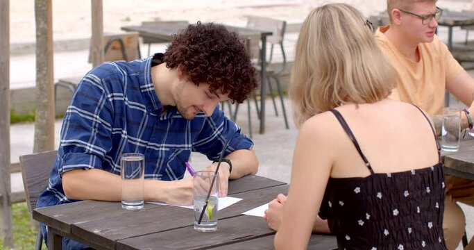 Couple on a speed dating. Young man fills out a form with questions. Participants are filling out questionnaires at speed dating events to helping people get to know each other quickly and efficiently