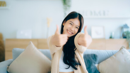 Happy teen asian girl blogger smiling face waving hand talking to webcam recording vlog, social...