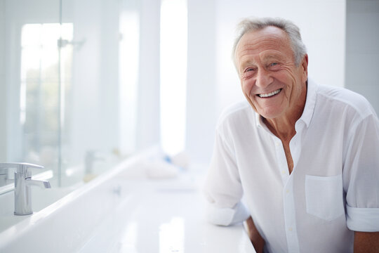 Elderly man smiling with the mirror in the bedroom white
