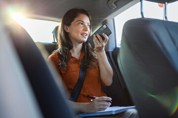 Fototapeta na wymiar Young girl uses a mobile phone in the car. Technology cell phone isolation. Internet and social media. Woman with smartphone in her car. Girl is using a smartphone in car