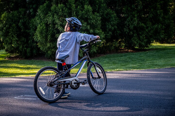 Young boy ridingbike on suburban street.