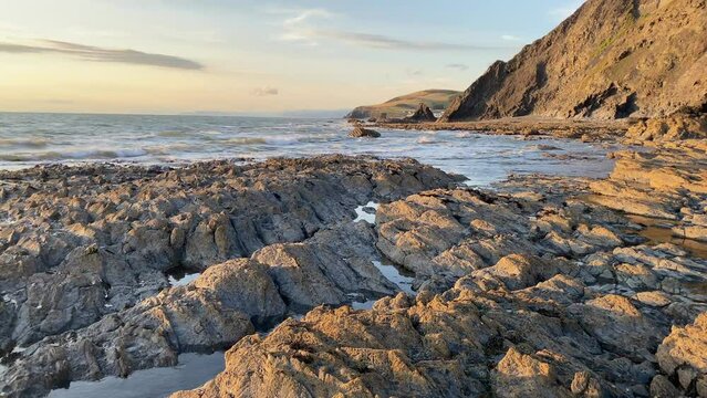 Evening tide on the dramatic coast in Aberystwyth at sunset