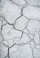 Close up of gray colored dry cracked dirt from above.