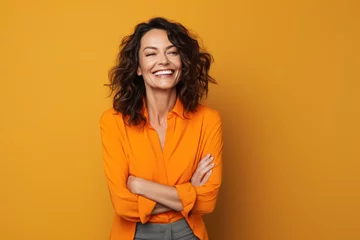Draagtas 40 - year - old woman wearing a bright clothes next to a orange background. Beautiful businesswoman, who is smiling and laughing at isolated background. © radekcho