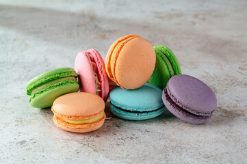 multicolored macaroon cookies lie on a white kitchen table
