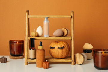 A wooden shelf with facial care products and a pumpkin