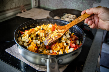 art of French cuisine: a chef expertly saut?ing ratatouille ingredients in a frying pan.