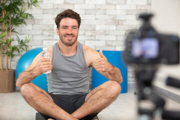 young male sport blogger recording video at home