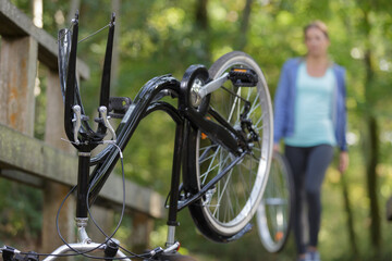 Obraz premium young woman repairing mountain bike in the forest