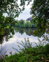 Glatter kleiner See mit klarer Spiegelung und Enten