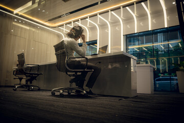 Side view of young businessman sitting at desk in office and looking away, Business disappointment...