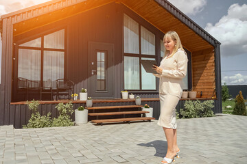 Woman real estate agent checks description of offered house from estate management company. Blonde...