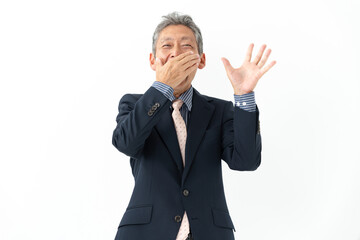 口を抑えて驚くシニア男性