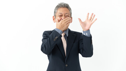 口を抑えて驚くシニア男性