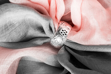 Silver ring on draped fabric