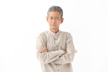 腕組みをしながら考えるシニア男性