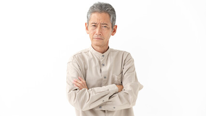 腕組みをしながら考えるシニア男性