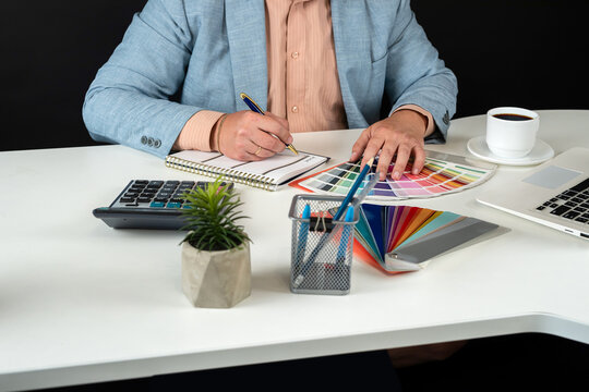 Men designer work with color catalog at office