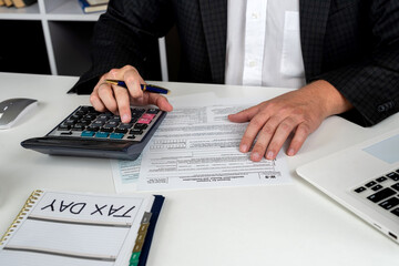 man hand using calculator for accounting  individual income 1040 tax form