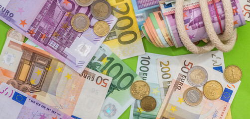 pile of different paper euro banknotes and coins cent