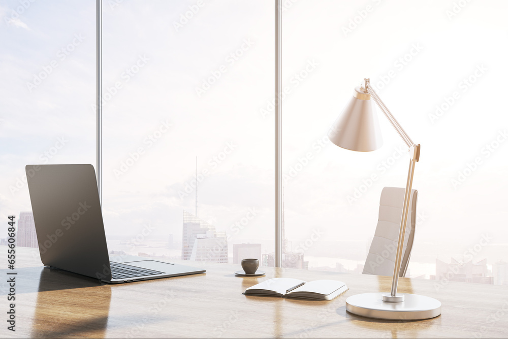 Poster close up of modern backlit wooden desk with laptop, table lamp, coffee cup and panoramic window with