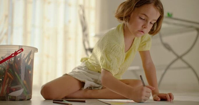 The girl draws with pencils on the floor at home. child and art development of world perception. High quality 4k footage