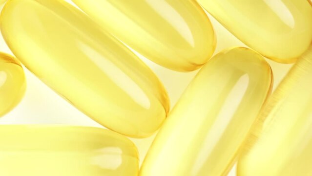 Food supplement oil filled. Capsules with omega 3 or vitamin A, E, fish oil. Macro shot, slow motion, top view. Pills background, capsules texture