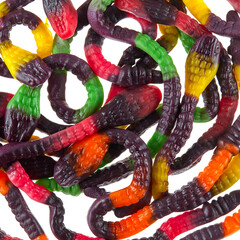 Texture of randomly scattered gelatin candies made in the form of colorful snakes. Gelatin cobras. - 655613015
