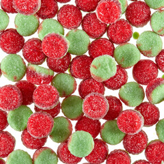 Texture of randomly scattered gelatin candies of red-green colors, in the form of buns sprinkled with sugar. - 655615229