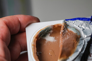 Close up of moldy mold on  cup of yogurt