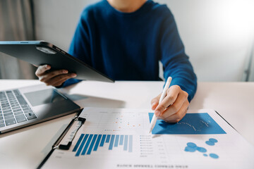businesswoman working with digital tablet computer and smart phone with financial business strategy layer effect on desk