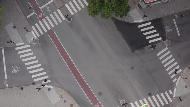 Top down view of scandinavian roads, crosswalks and cars driving on Uggleviksv&auml;gen and Karlav&auml;gen on &Ouml;stermalm in Stockholm, Sweden. Drone shot flying upwards