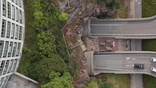 Top down view of cars and traffic going into tunnel in Roslagstull heading towards Liding&ouml;, Stockholm, Sweden, Sverige. Drone shot panning left mid day.