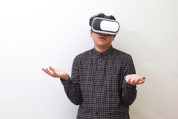 Portrait of Asian man in black plaid shirt using Virtual Reality (VR) glasses and thinking with...
