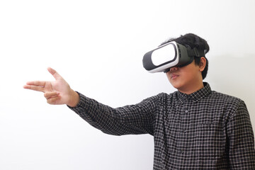 Portrait of Asian man in black plaid shirt using Virtual Reality (VR) glasses and greet his friend inside the game with opened palm. Isolated image on white background