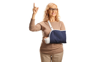 Woman with injured arm wearing a sling and pointing up
