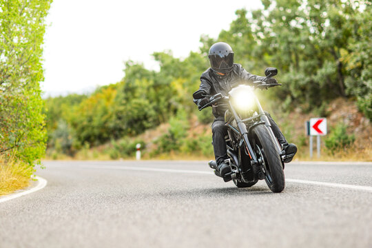 Man riding a chopper bike on an asphalt road