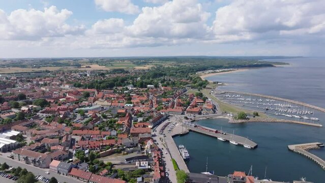 Aerial forward over the beautiful port city Simrishamn in Sweden, summer day