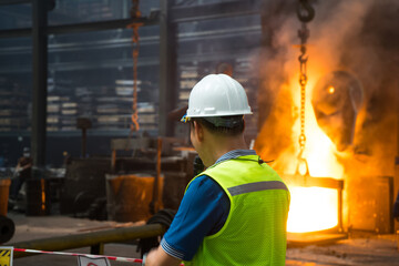 Engineer or Technician to control production of steel casting that Our foundry can produce high-quality custom metal castings. Use heat at high temperatures and intense flames at industrial plant. - obrazy, fototapety, plakaty