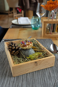 Hazelnut dessert served in a wooden box with forest details